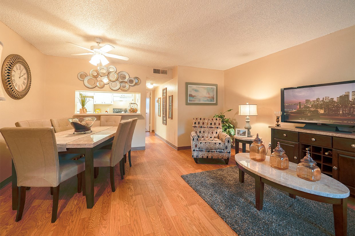 a living room and dining room with a table and a television